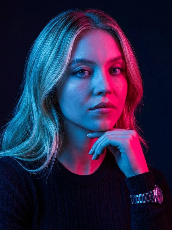 Woman in a dark sweater with blue and magenta studio lighting